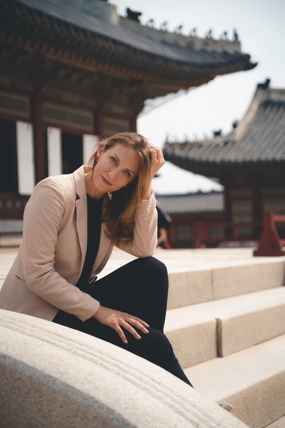 Darcie Draudt-Véjares seated beside Korean palace architecture